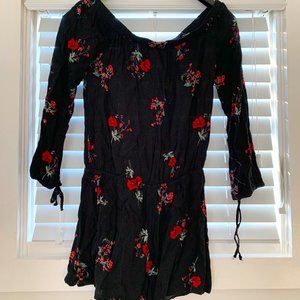 Black long sleeve romper with red floral design, off the shoulder